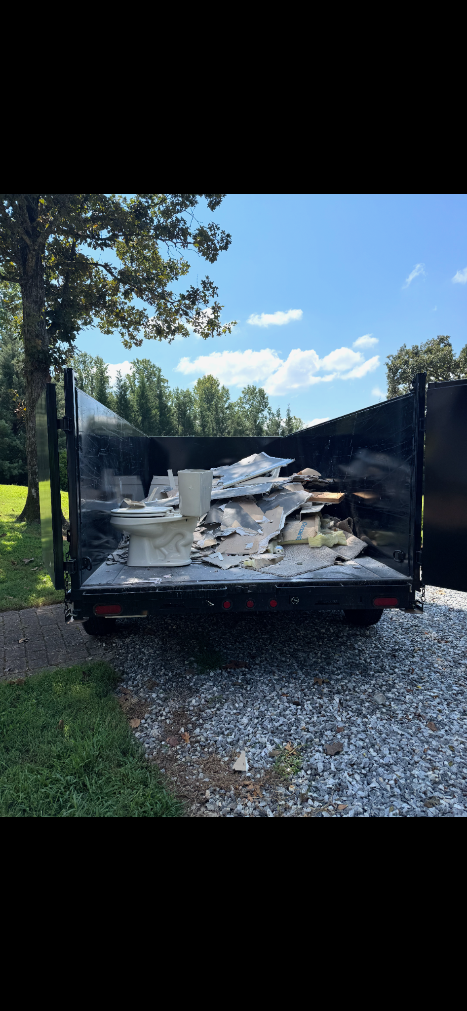 Dump trailer loaded with drywall and renovation debris