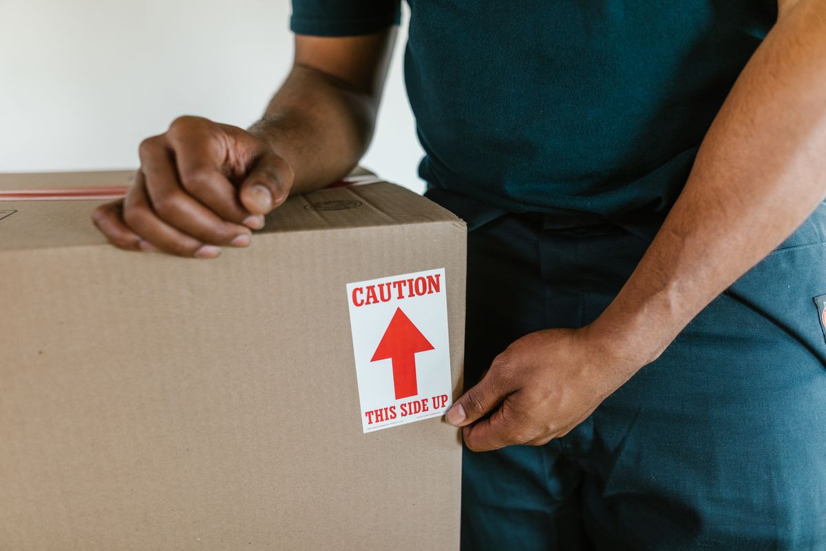 Hands preparing a box for transport