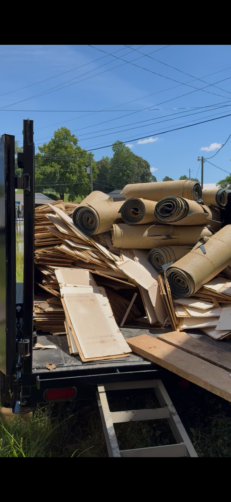 Wood flooring and rolled carpet loaded into the trailer