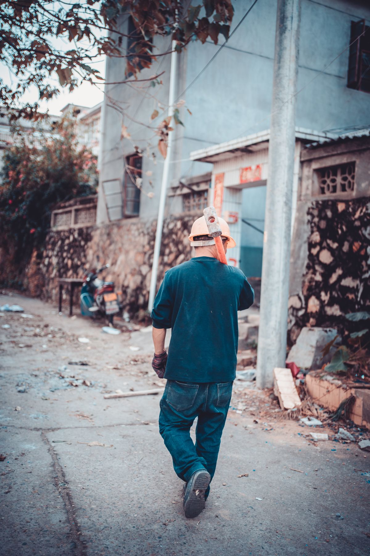 Worker carrying a sledgehammer at a renovation site