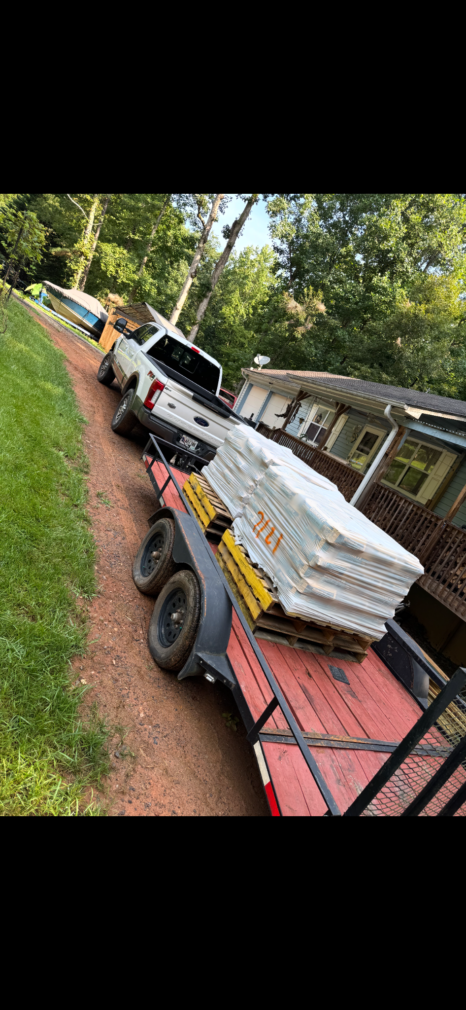 Pickup truck and flatbed trailer carrying bagged materials