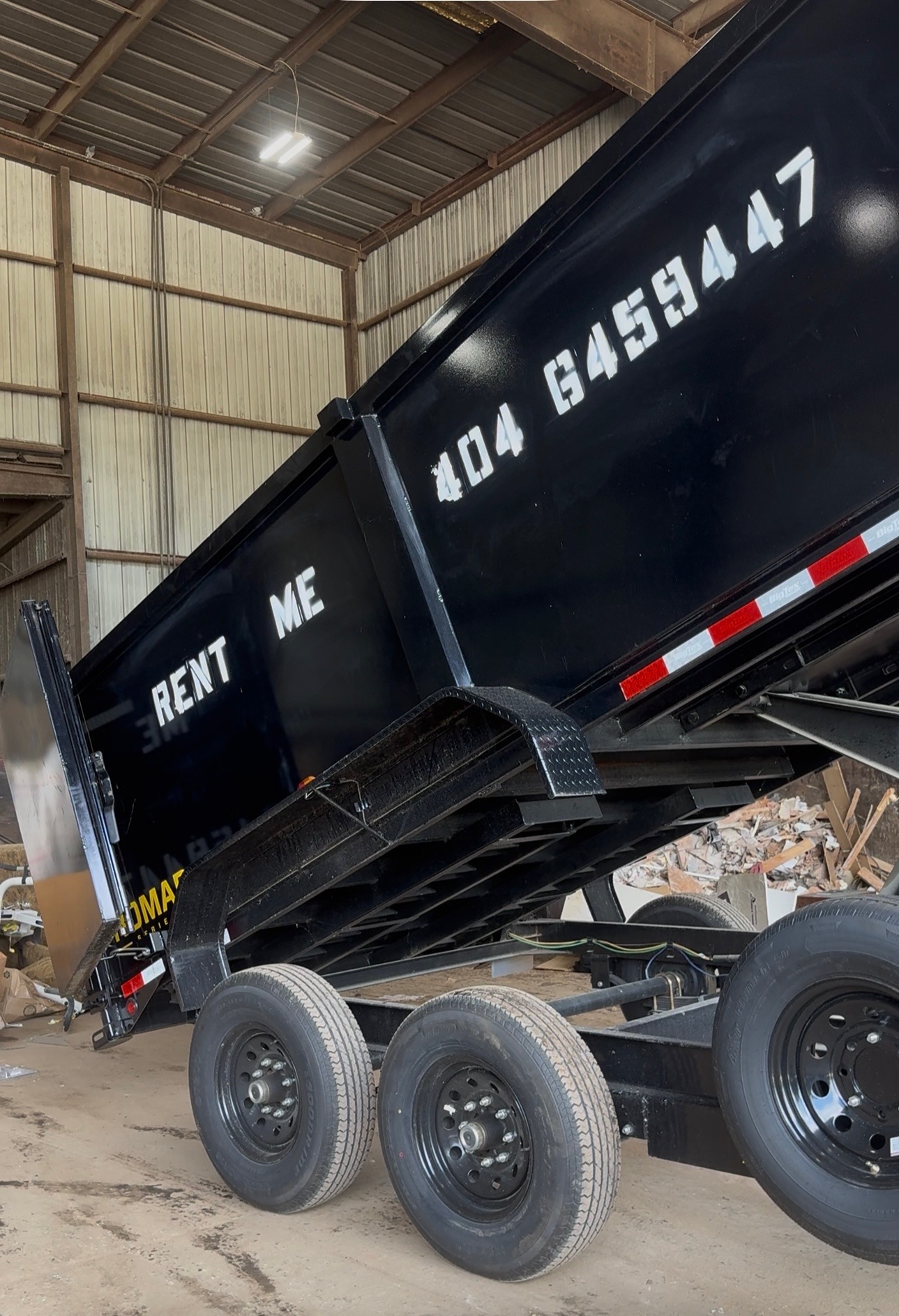 Black dump trailer raised at a cleanup site